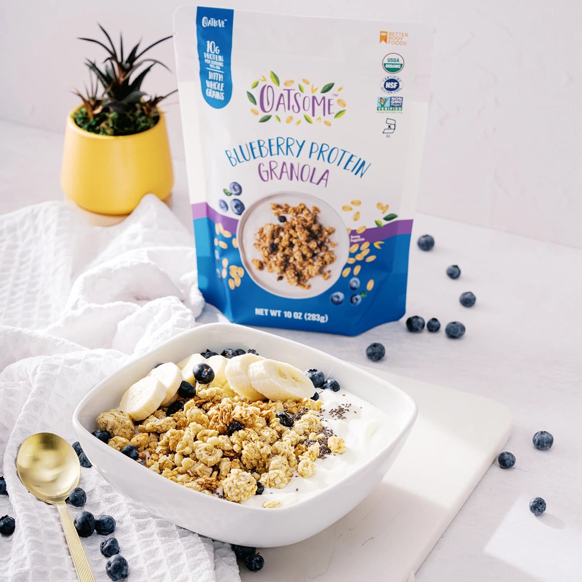 Oatsome products arranged in a picnic basket with a refreshing drink